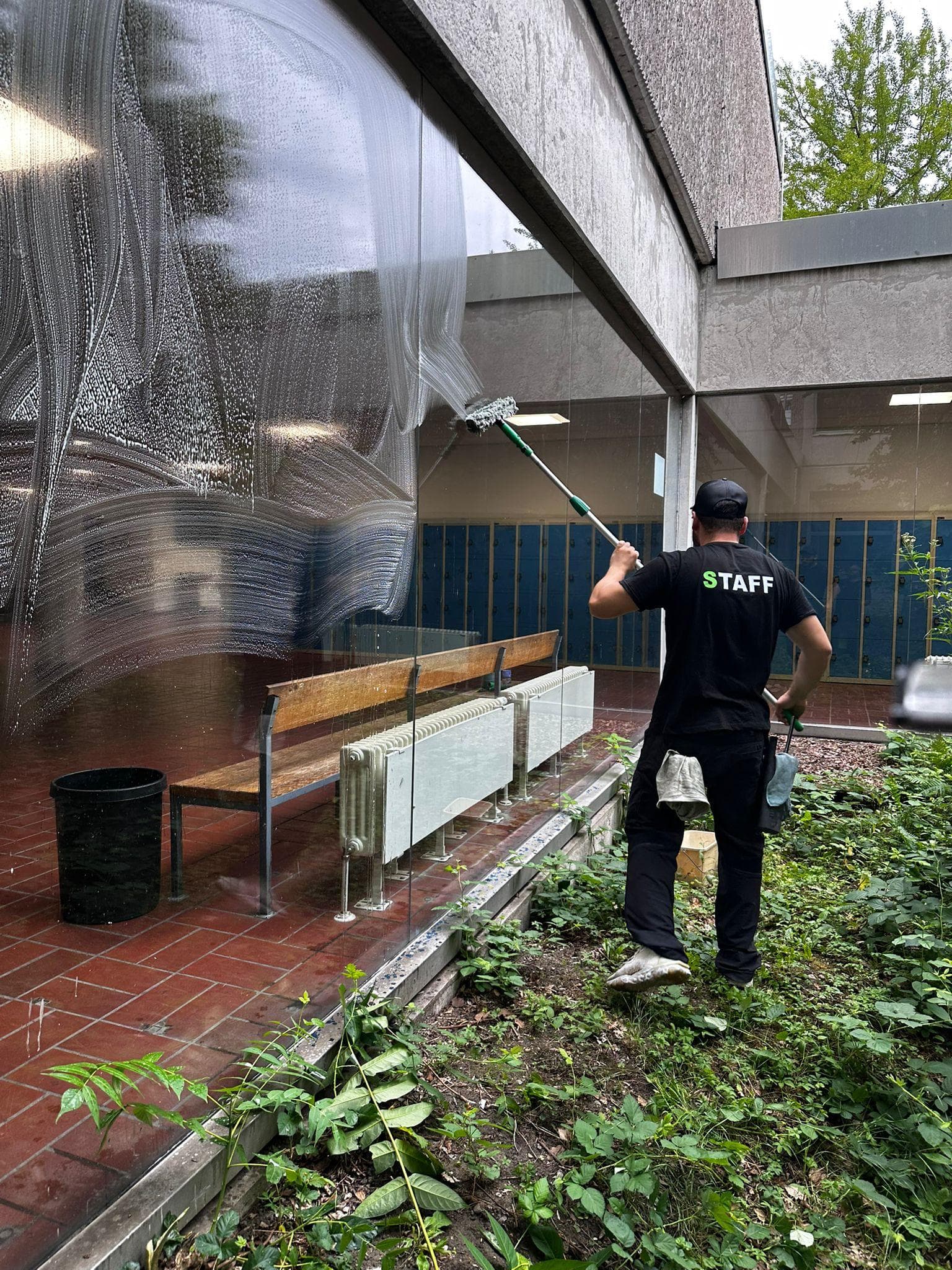 Fensterreinigung mit Seifenfilm an einer Glasfront