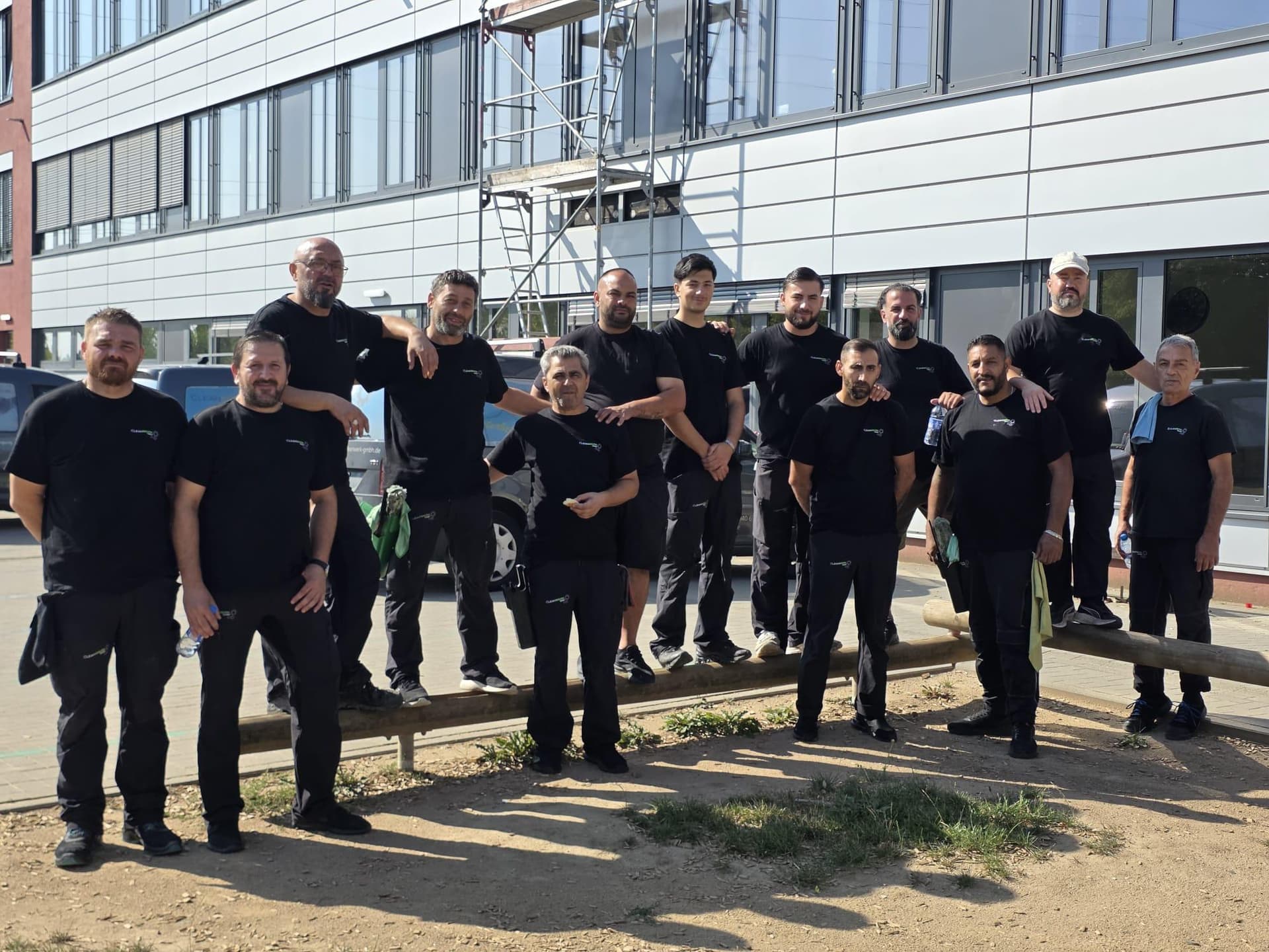 Cleanwerk-Team in Gruppenaufnahme vor einem Bürogebäude