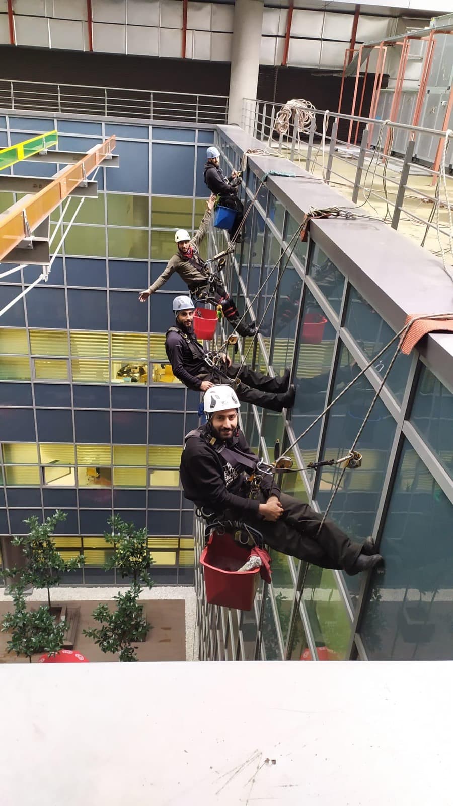 Cleanwerk-Team im Seilzugang an einer verglasten Atriumfassade